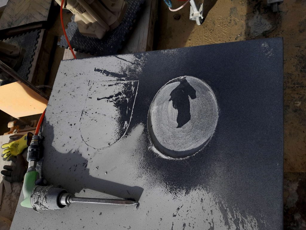 voorhakken van de contour in zwart graniet