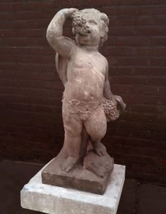 Putto met druiventros. Deel van twee zandstenen putti