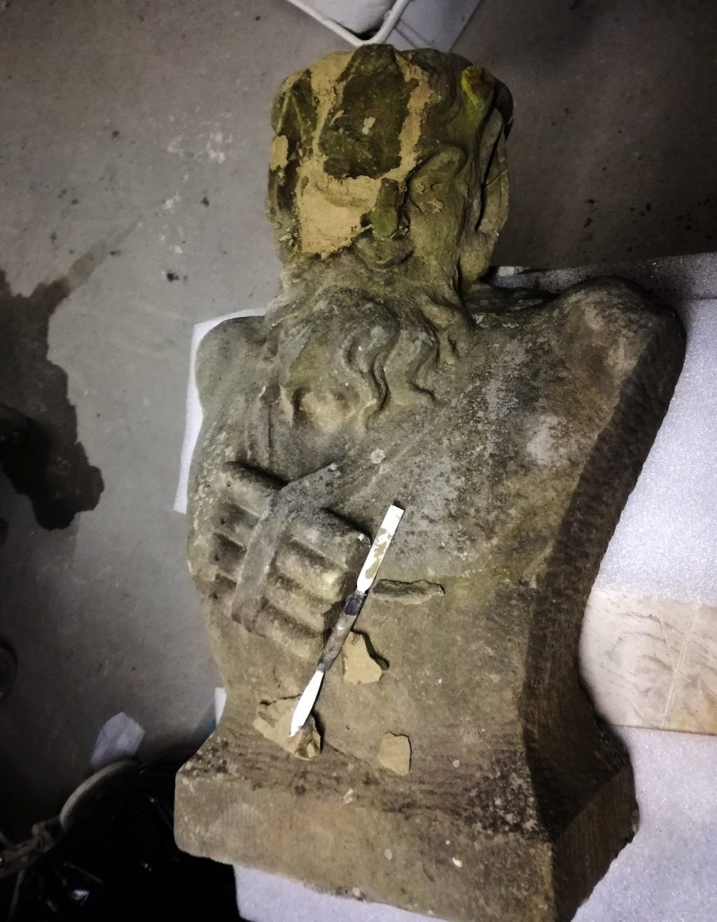 herstelwerkzaamheden aan een gebroken faun van zandsteen