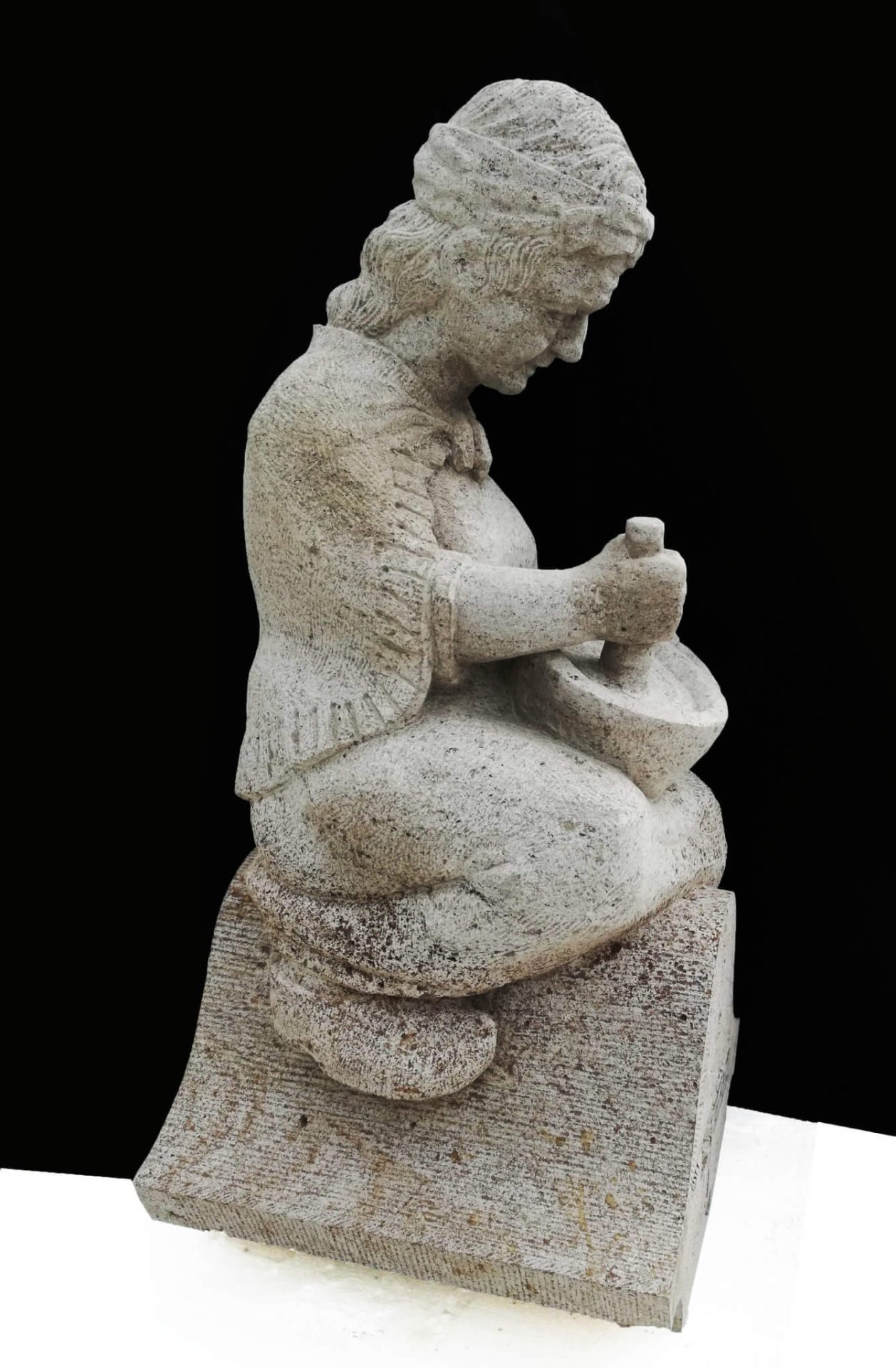 kopie in Muschelkalksteen van een beeld je van een oude dame met vijzel