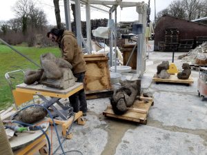 luchtboogbeelden 'De Zeven Zonden' worden verlijmd door Jelle Steendam op het erf van Beeldhouwerij van Velzen