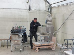 Bildhauer Koen van Velzen mit Fassadenstein in der Werkstatt