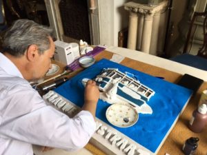 Rómulo Döderlein de Win schildert de gevelsteen van de Blauwe Tramstraat