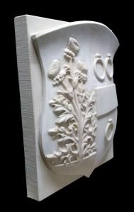 Een wapensteen met familiewapen in Bentheimer zandsteen. Het wapen bevat drie ringen, een balk en een driebloemige distel