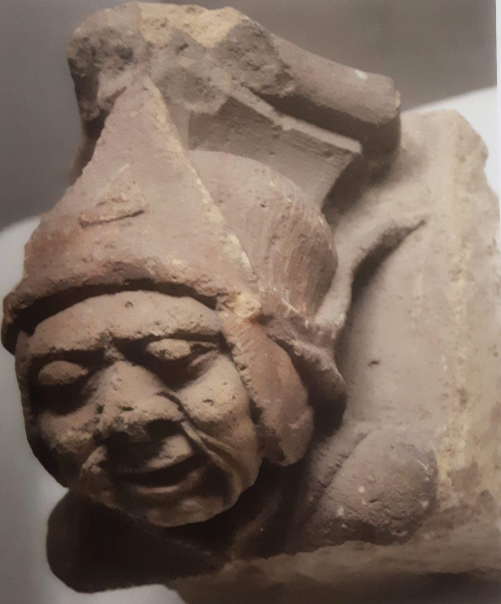 oude kraagsteen met hoofdje van man met muts