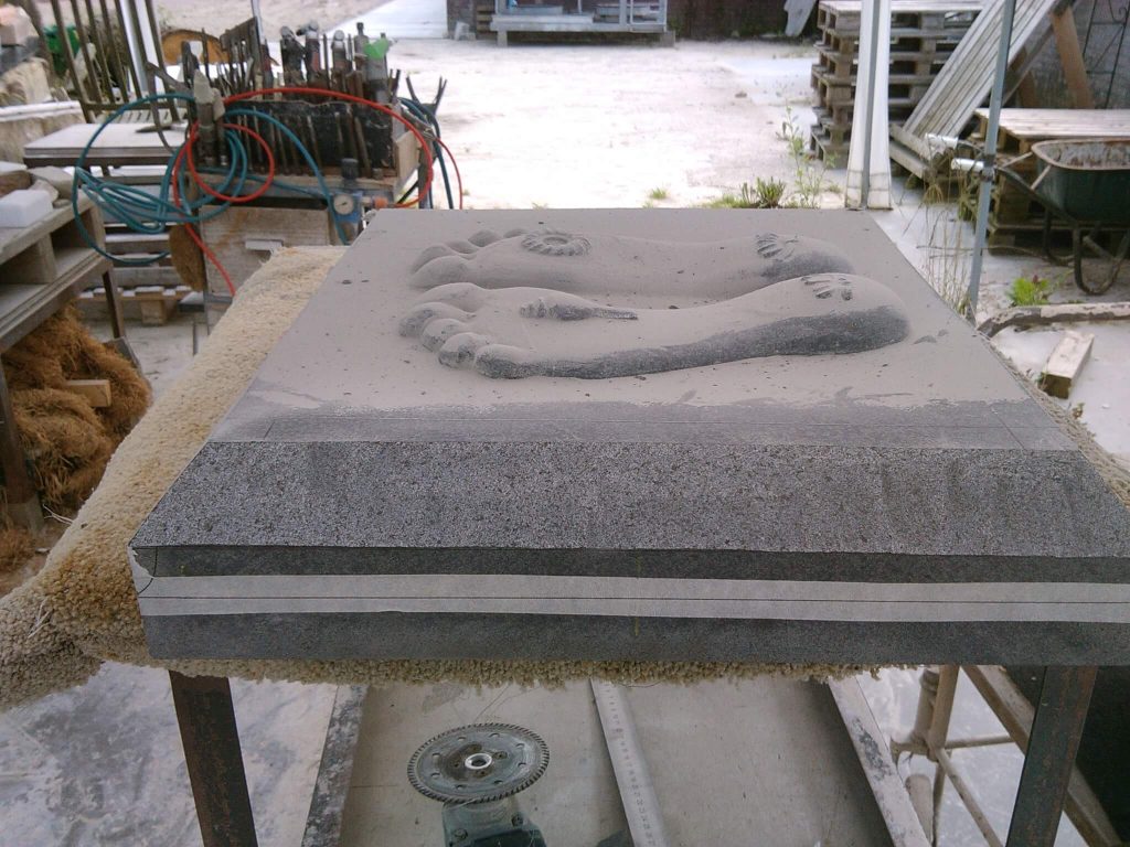 Schnitzen traditioneller Padukas aus schwarzem Granit