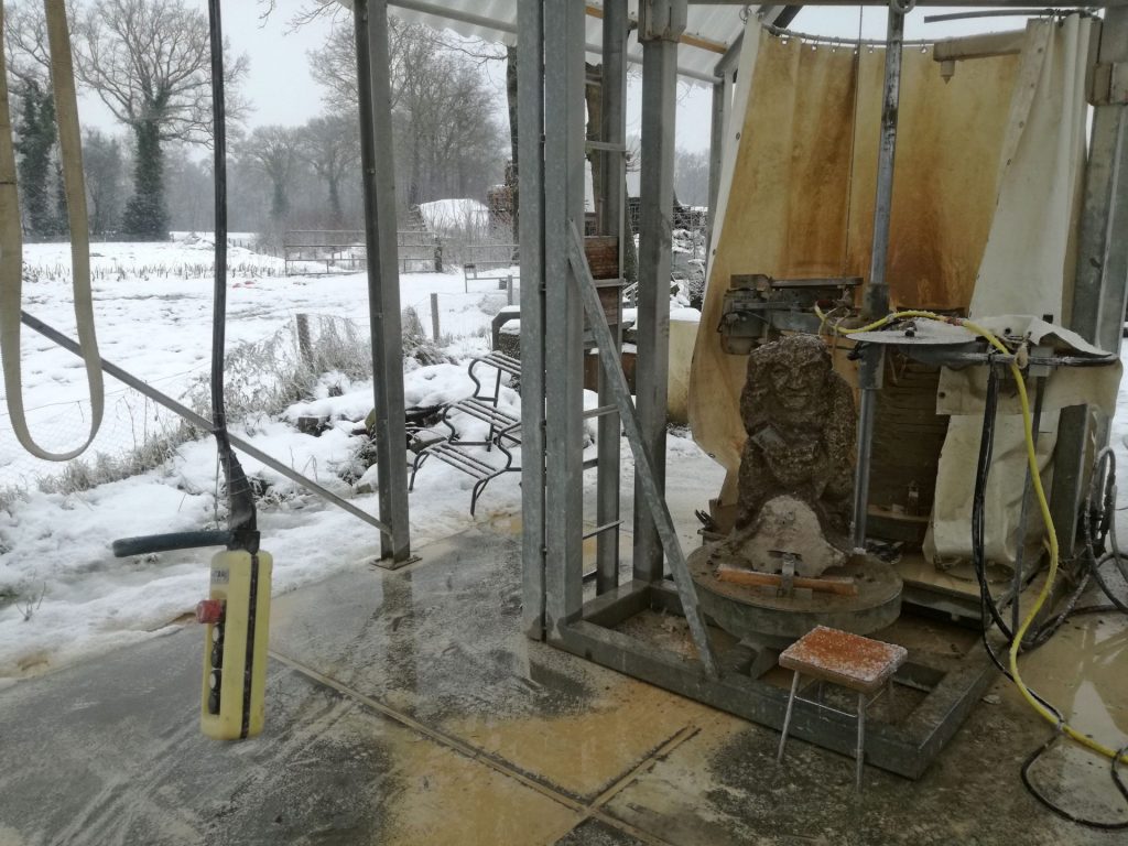 stenen beelden voorzagen met zaagmachine in de sneeuw